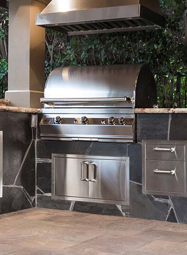 ourdoor kitchen grill embedded in gray stone