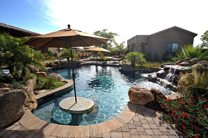 Oasis backyard with pool and small waterfall