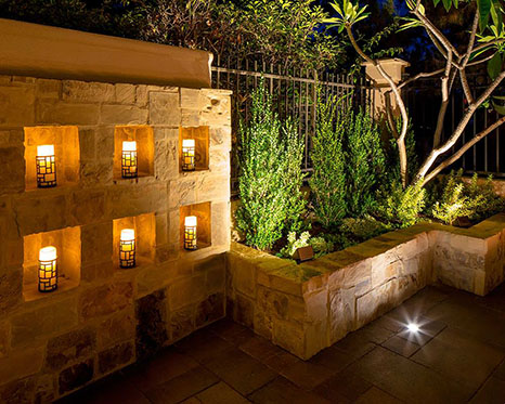 paver wall with inset candles and a low retaining wall for raised bed garden